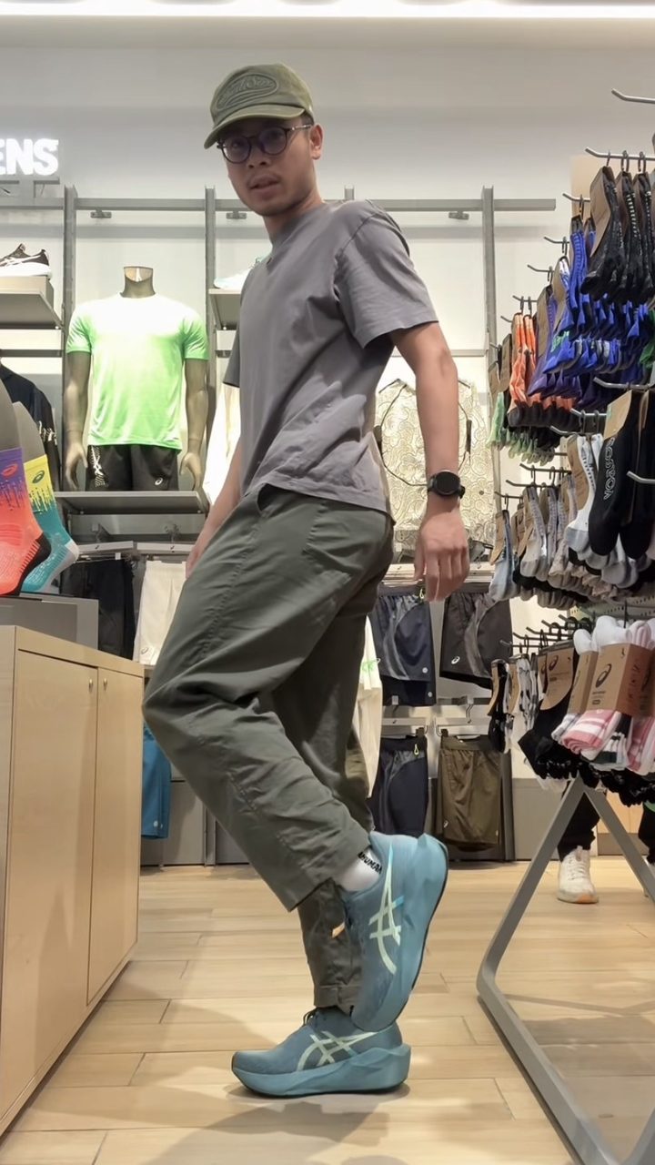 Haziq showing ASICS Novablast 6 shoes in an ASICS store